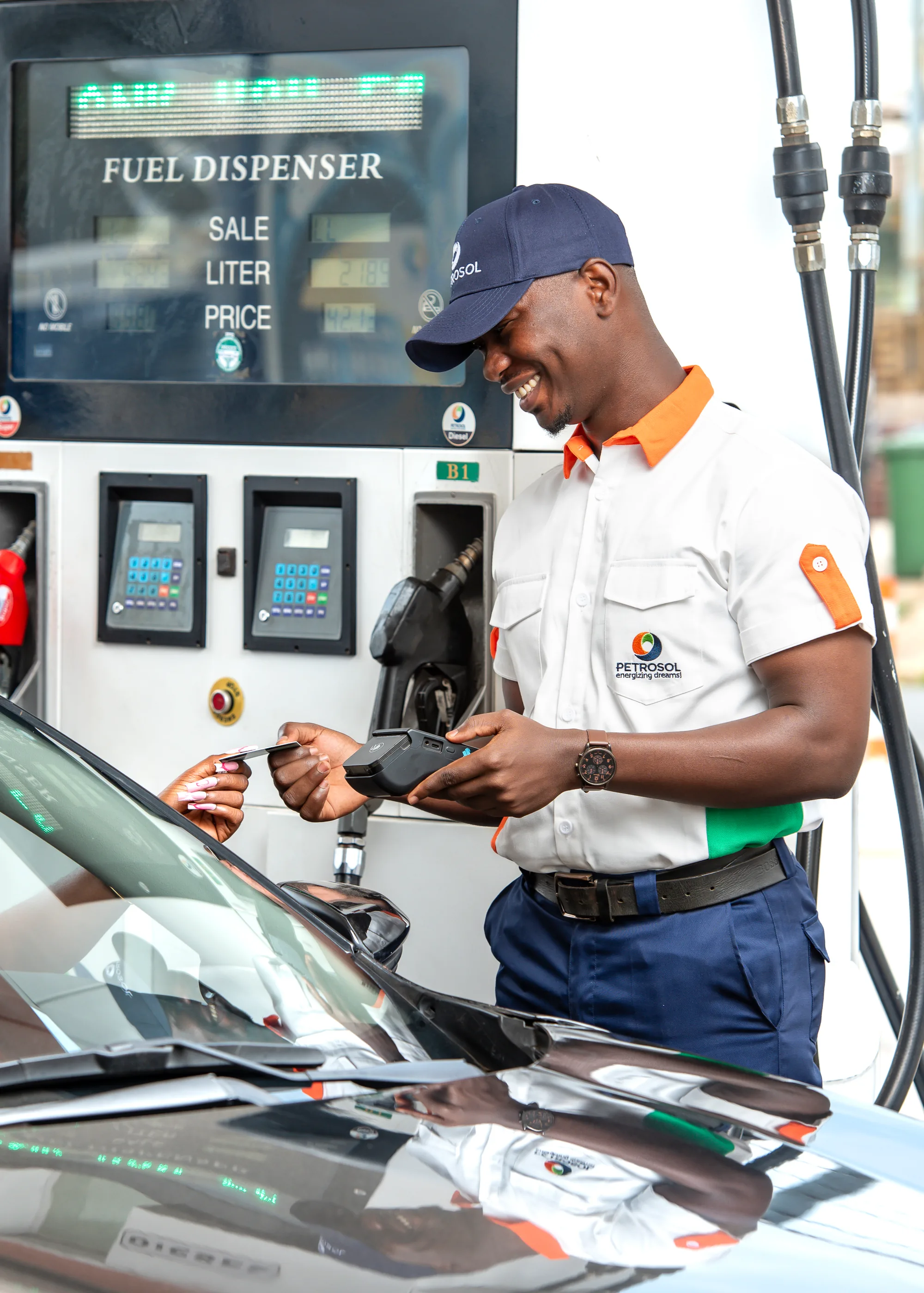 A PETROSOL attendant taking card payment at the pump