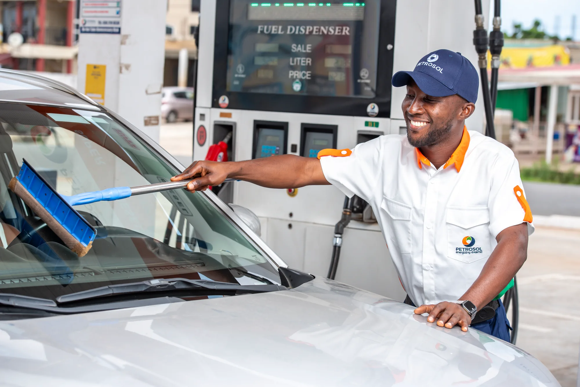 A PETROSOL attendant cleaning a customer's windscreen
